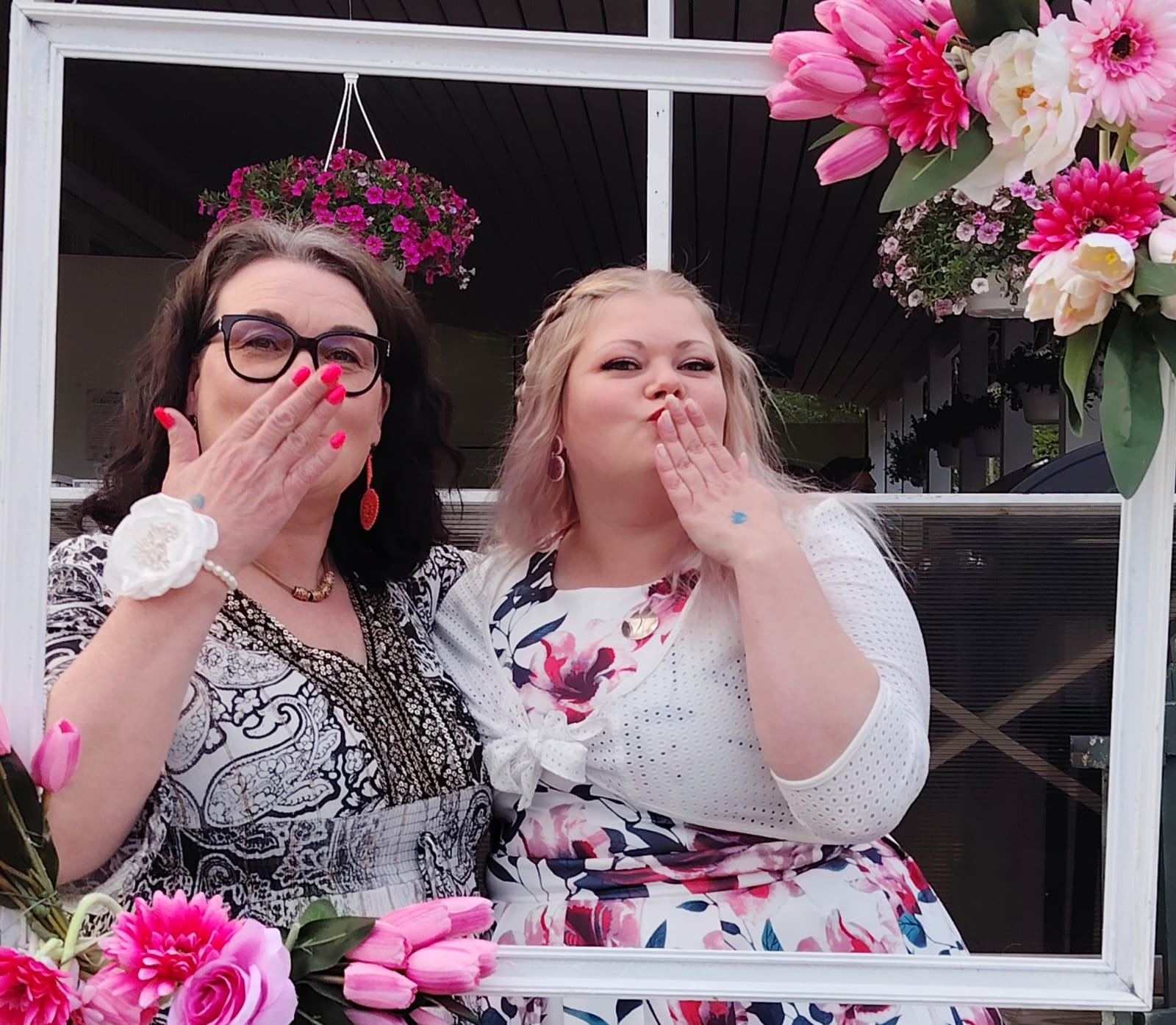 Naiset kukkamekoissa lähettämässä lentosuukkoja